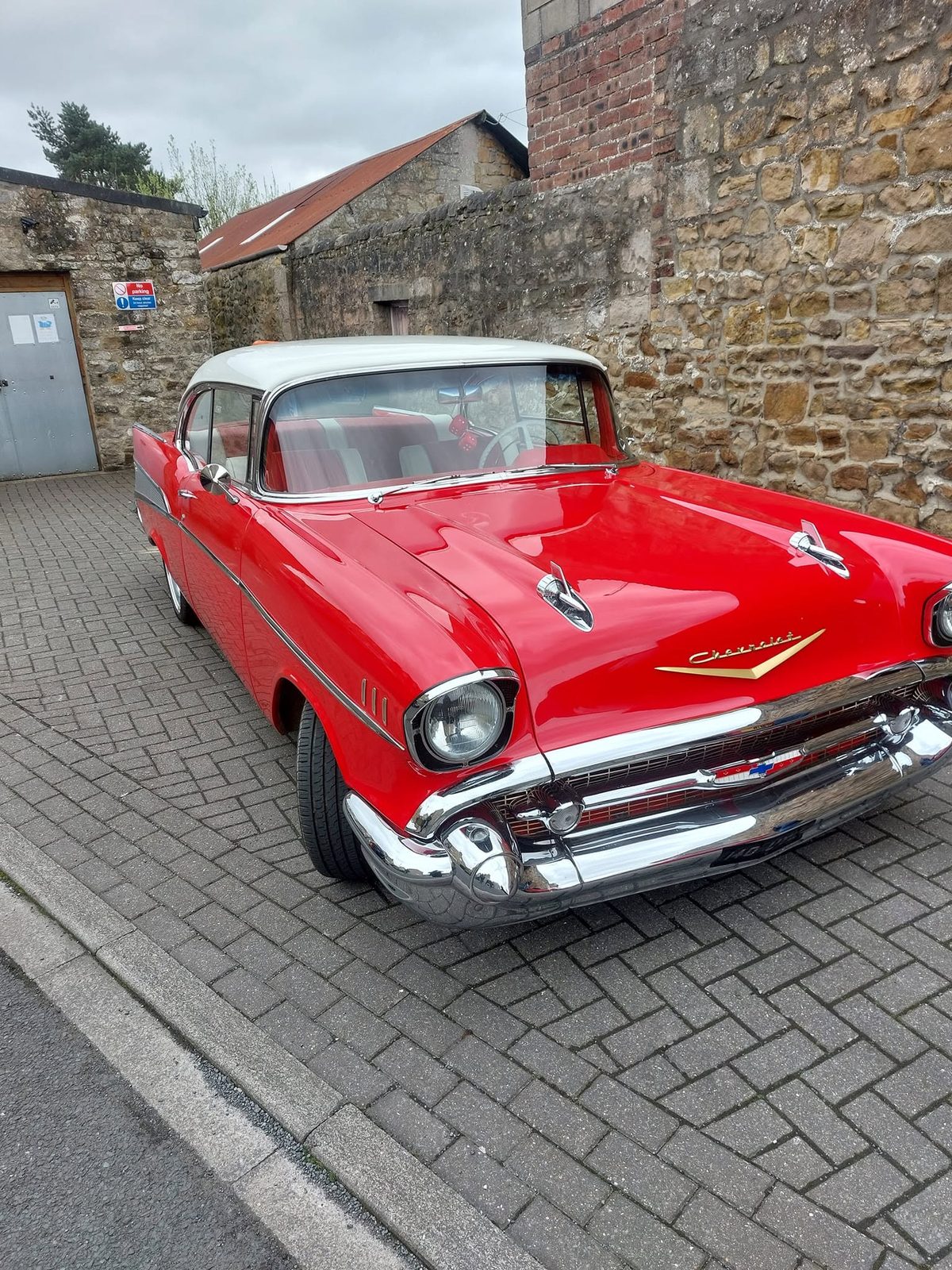 A red and white classic Chevrolet in the yard