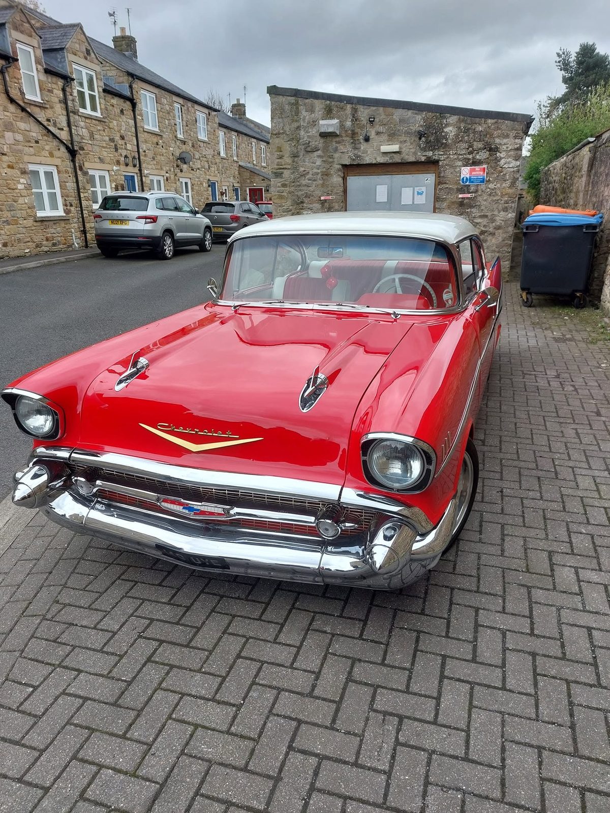 The classic Chevrolet in the yard with stone cottages behind