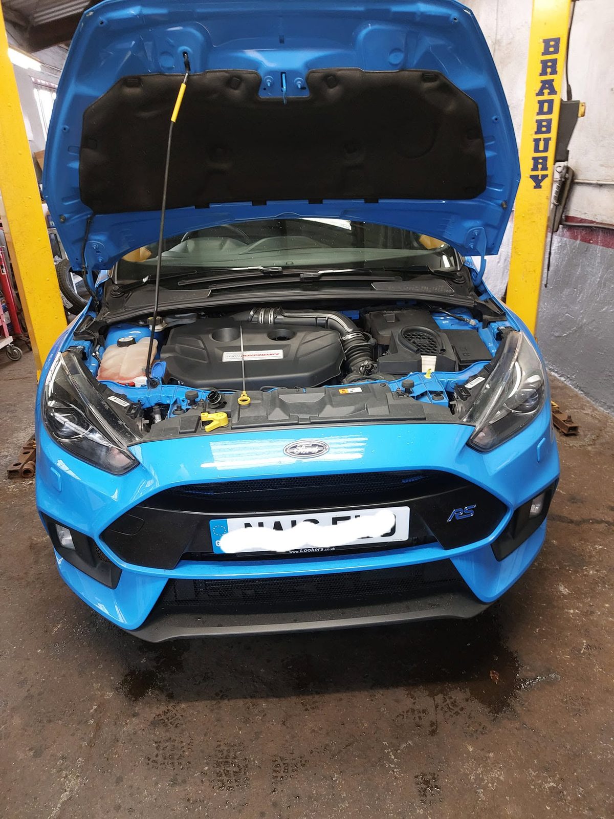 Blue Ford Focus RS on the lift with the bonnet up