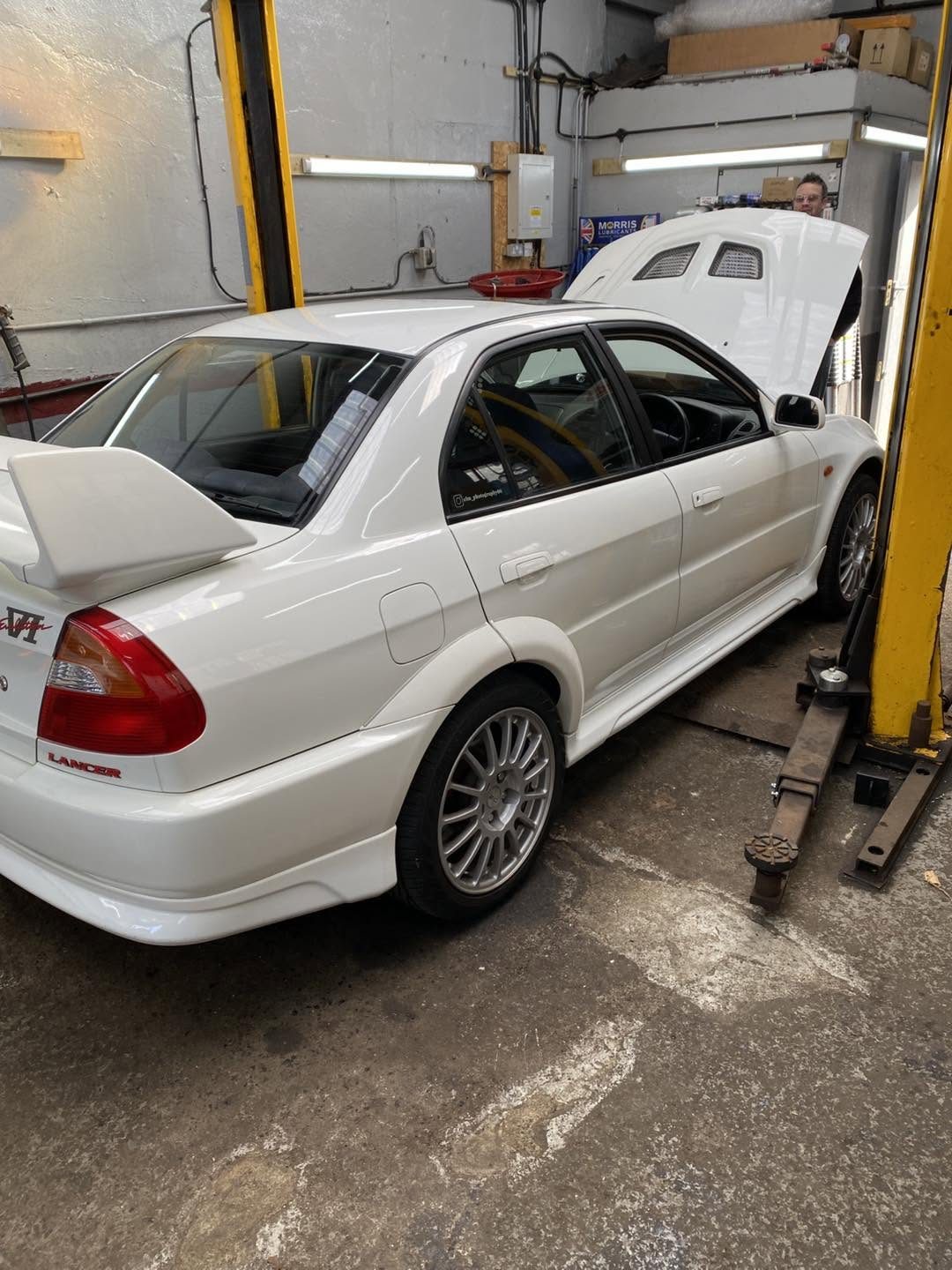 White Mitsubishi Lancer Evo on the two-post lift