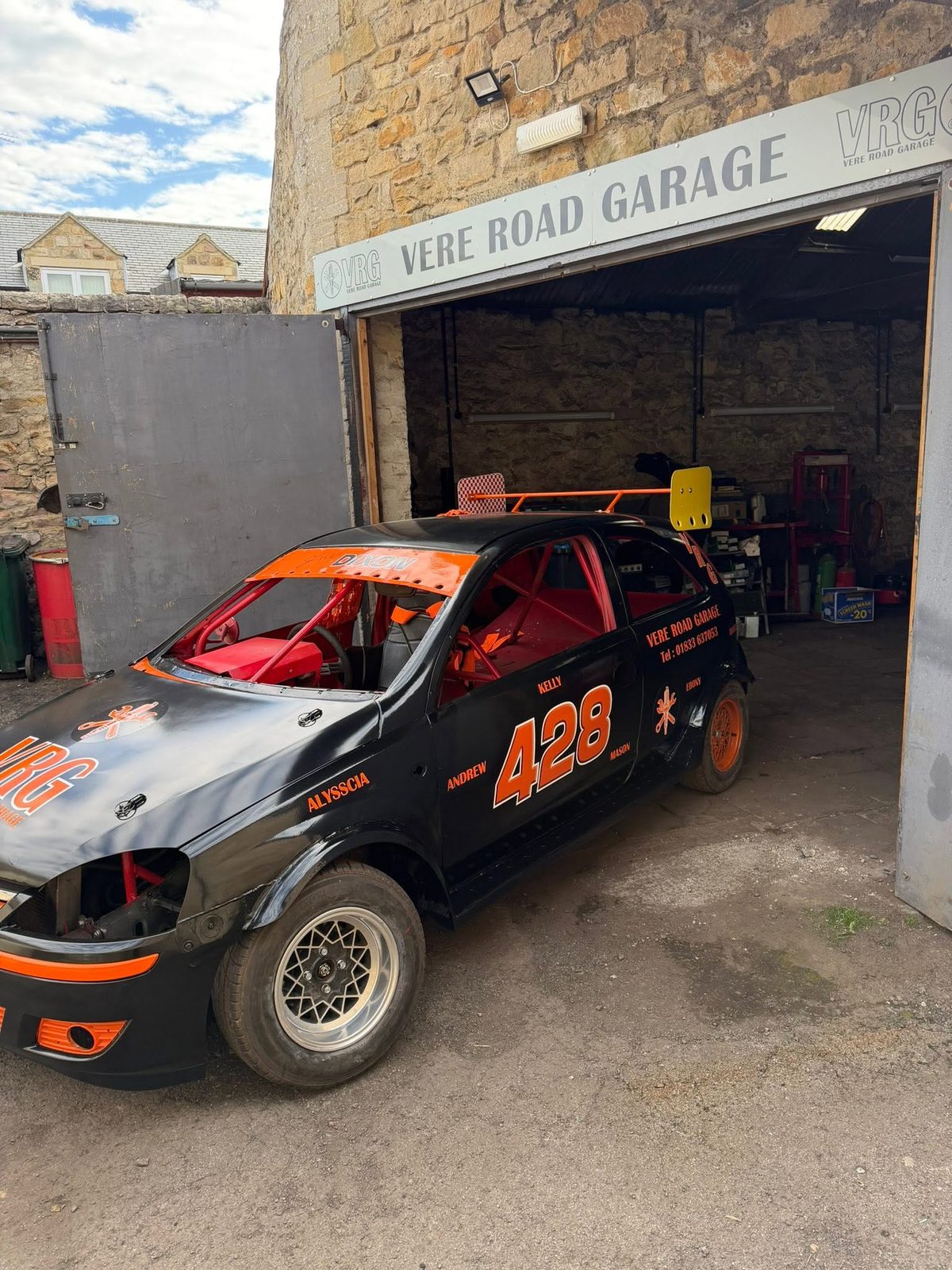 The black and orange VRG race car, number 428, in the bay