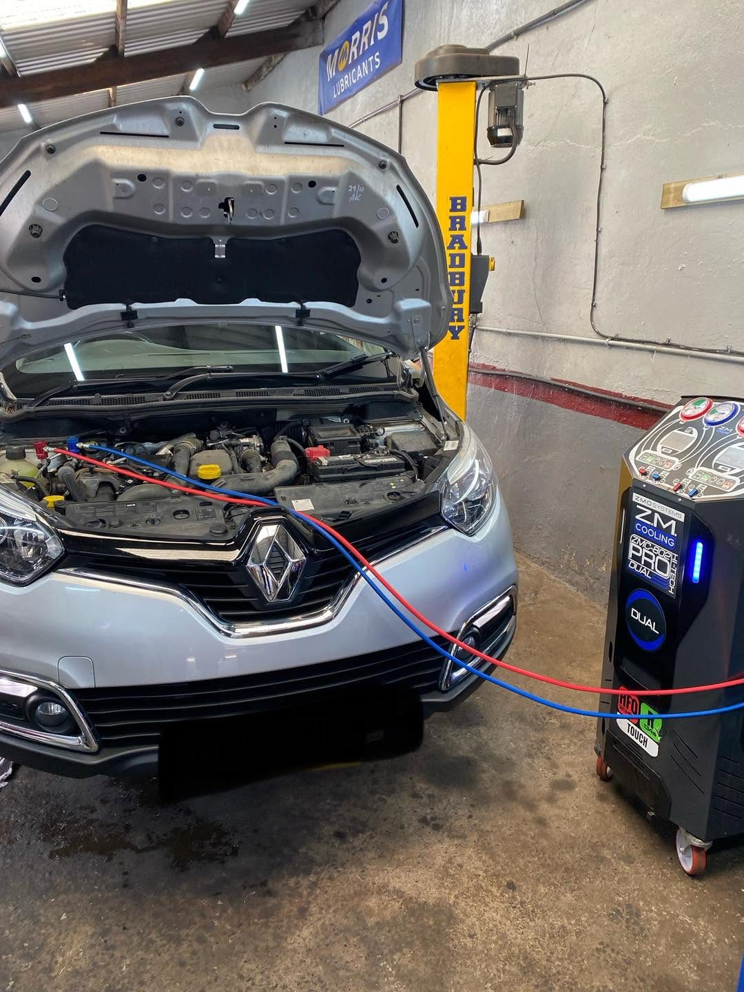 Renault with its bonnet up, connected to the workshop machine