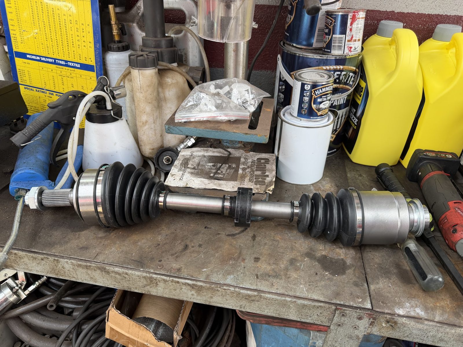 Parts on the workbench beside oil, fluids and tools